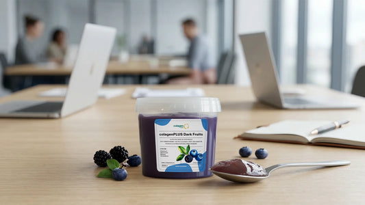 ColagenPlus Dark Fruits pe birou, alături de lingură și fructe de pădure, pentru un prânz nutritiv rapid la birou